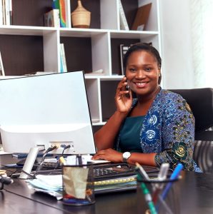 Professional African American woman smiling while working at her desk in an office.