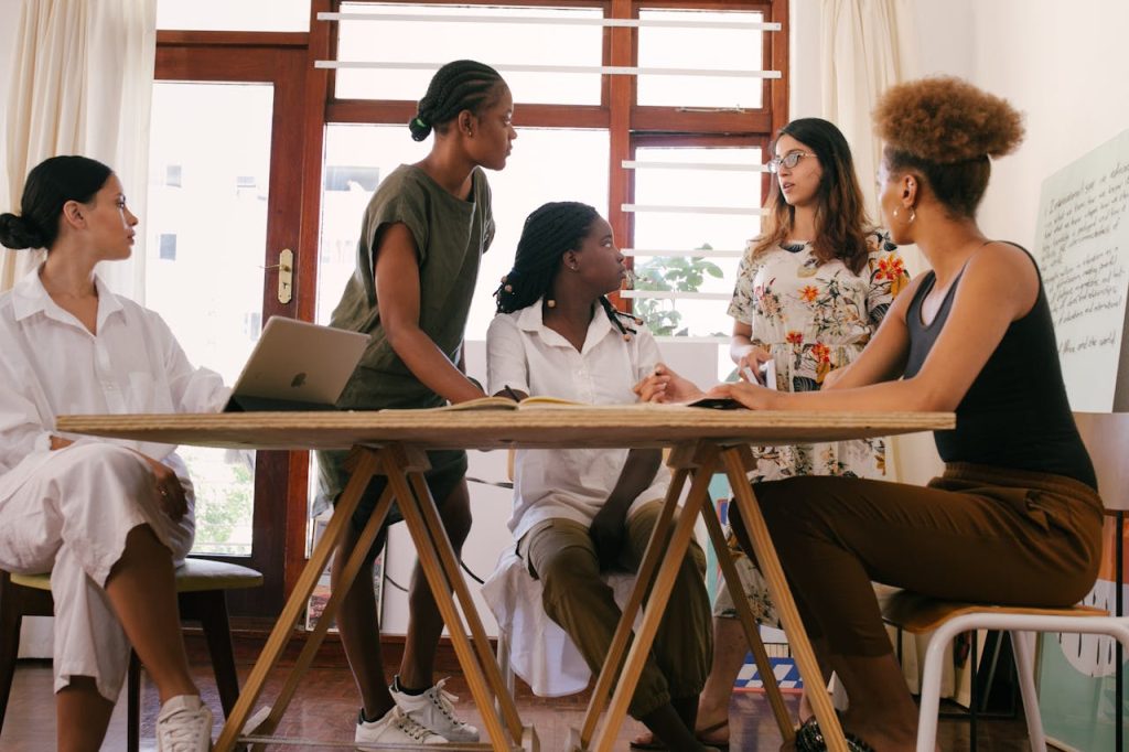 women-at-the-meeting-3810753 A diverse team of women brainstorming ideas in a modern office setting, fostering collaboration and creativity.
